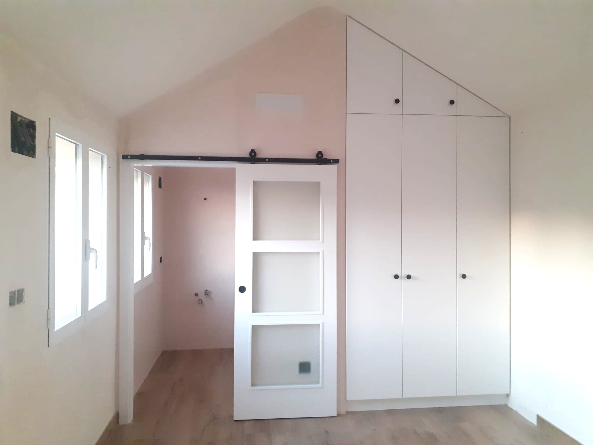 Armario a medida abuhardillado con puerta corredera en dormitorio bajo cubierta — después