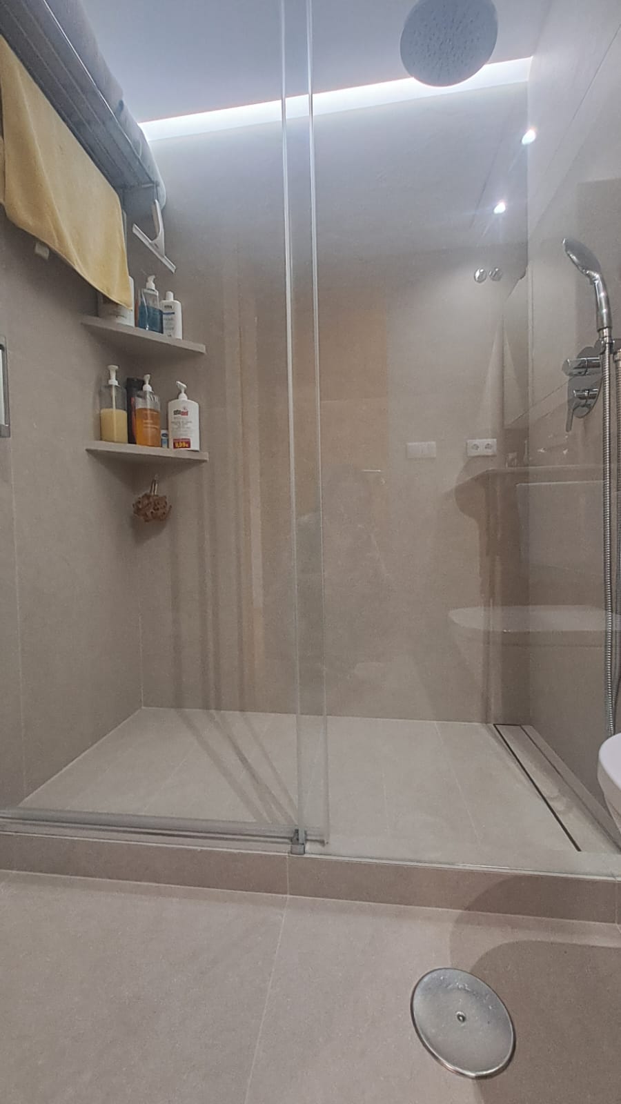 Baño reformado con ducha de obra, mampara de cristal y ducha efecto lluvia