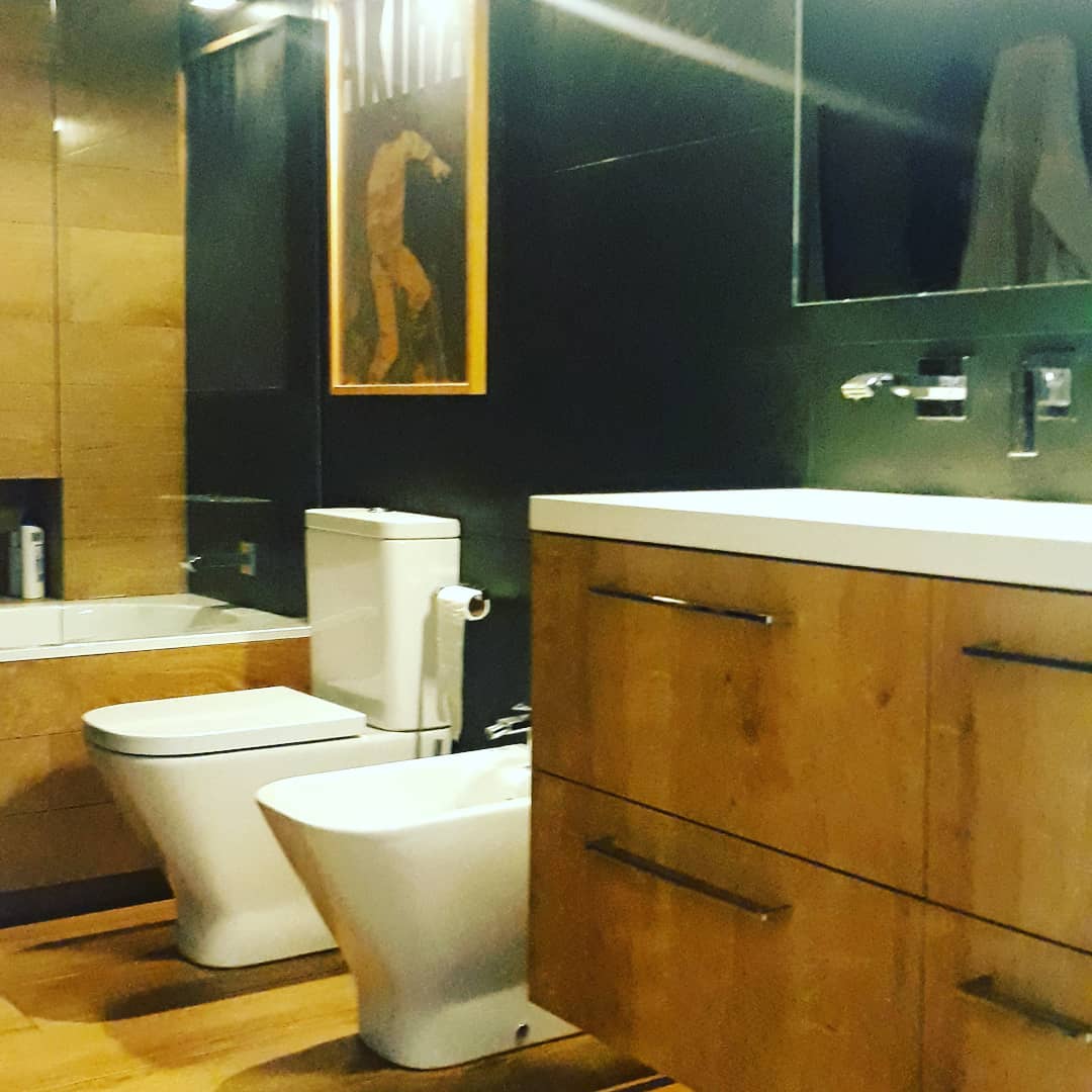 Baño moderno con mueble de madera y grifería empotrada